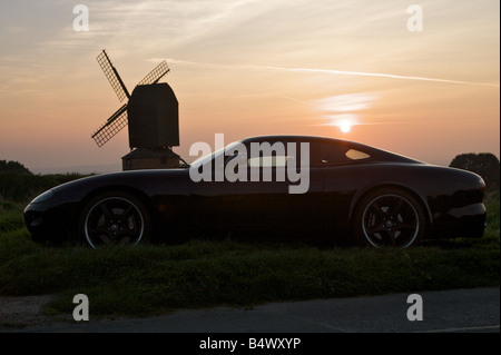 Voiture Jaguar moderne au coucher du soleil. Banque D'Images