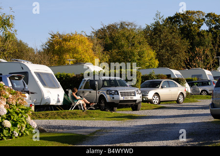 Camping site dans le sud du Devon England UK Femme assise et la lecture d'un livre dans ce site bondé Banque D'Images