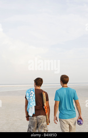 Young Men Walking on beach Banque D'Images