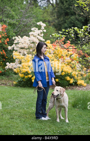 Girl walking dog in park Banque D'Images