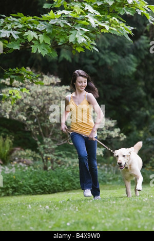 Fille courir dans le parc de chien Banque D'Images