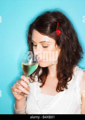 Jeune femme reniflant le vin blanc Banque D'Images