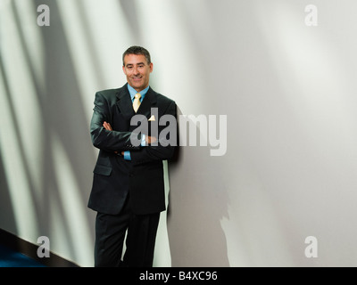 Businessman leaning against wall Banque D'Images