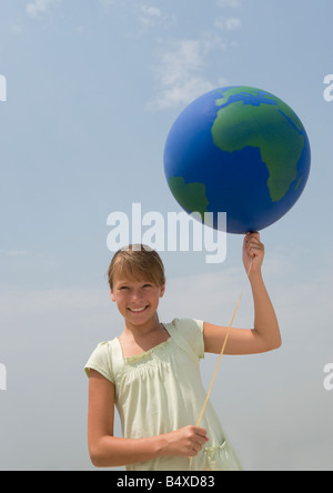 Girl holding globe balloon Banque D'Images