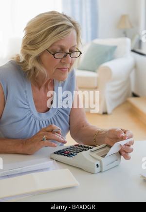 Femme à l'aide de l'ajout de machine à l'accueil Banque D'Images