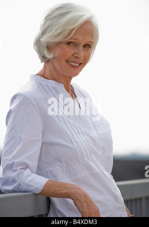 Senior woman leaning on railing Banque D'Images
