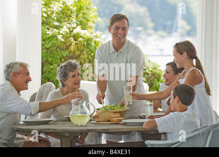 Multi-générations family eating on porch Banque D'Images