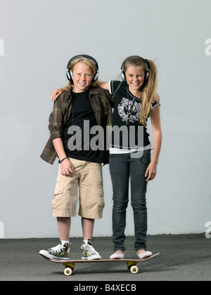 Deux enfants sur une planche à roulettes Banque D'Images