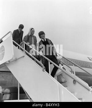 John Lennon et sa petite amie Cynthia Mai 1964 avec George Harrison descendre d'un avion de la Pan Am 707 à l'aéroport d'Heathrow après son retour de l'USA Swinging Sixties Collection Banque D'Images