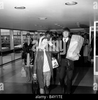 Groupe pop les Beatles Mai 1964 John Lennon Paul McCartney George Harrison Ringo Starr deux des Beatles arrivent à l'aéroport de Londres à l'arrière de leurs vacances George Harrison et petite amie Patti Boyd John Lennon avec épouse Cynthia Lennon Banque D'Images