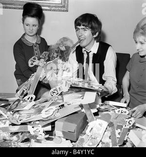 Groupe pop les Beatles Février 1964 George Harrison George Harrison des Beatles Collingham Anne 21e anniversaire avec ventilateur secrétaire du club Anne Collingham aidant à trier les 52 sacs pleins de cartes de vœux et des colis Banque D'Images