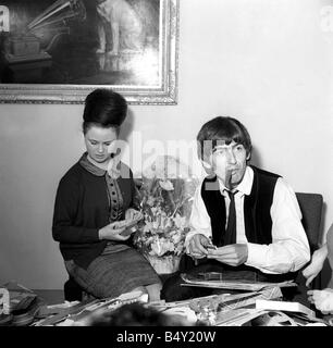 Groupe pop les Beatles Février 1964 George Harrison George Harrison des Beatles Collingham Anne 21e anniversaire avec ventilateur secrétaire du club Anne Collingham aidant à trier les 52 sacs pleins de cartes de vœux et des colis Banque D'Images