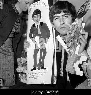 Groupe pop les Beatles Février 1964 George Harrison George Harrison des Beatles Collingham Anne 21e anniversaire avec ventilateur secrétaire du club Anne Collingham aidant à trier les 52 sacs pleins de cartes de vœux et des colis Banque D'Images