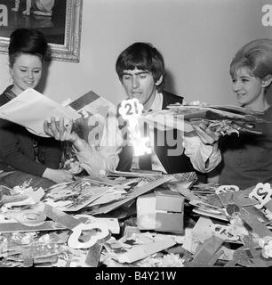 Groupe pop les Beatles Février 1964 George Harrison George Harrison des Beatles Collingham Anne 21e anniversaire avec ventilateur secrétaire du club Anne Collingham aidant à trier les 52 sacs pleins de cartes de vœux et des colis Banque D'Images