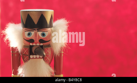 Un casse-noisettes avec un gland sur un fond rouge Banque D'Images