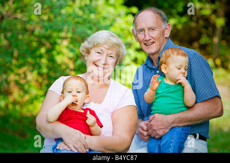 Petits-fils jumeaux roux Holding avec l'accent sur les grands-parents heureux Banque D'Images