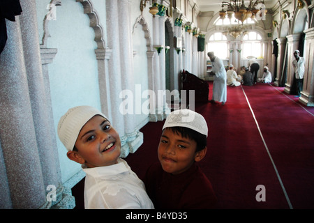 Deux garçons musulmans s'embrassent à l'occasion de l'Aïd al-Fitr (fin du Ramadan) à l'intérieur de la mosquée de Katmandou, Népal Banque D'Images