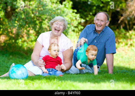 Jouant avec ses petits-fils jumeaux roux avec l'accent sur les grands-parents de rire Banque D'Images