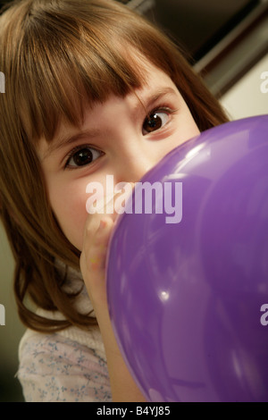 Petite fille de gonfler un ballon Banque D'Images