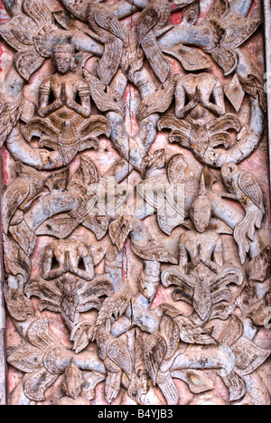 Porte en bois décorés dans un temple bouddhiste à Luang Prabang au Laos Banque D'Images