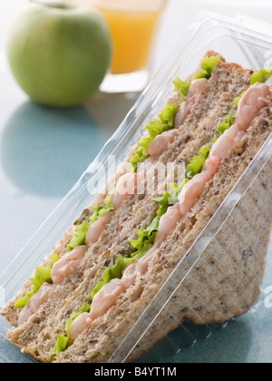 Marie Rose crevette et salade Sandwich sur pain grenier avec une pomme et du jus d'Orange Banque D'Images