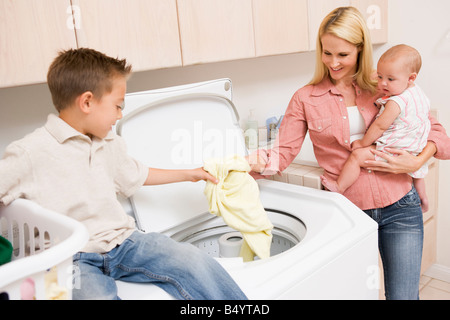 Mère et enfants faisant la blanchisserie Banque D'Images