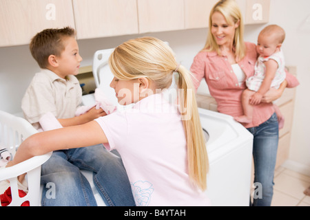 Mère et enfants faisant la blanchisserie Banque D'Images