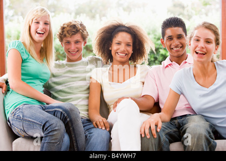 Groupe d'adolescents assis sur un canapé Banque D'Images