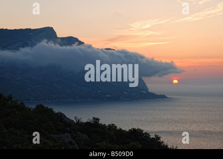 Un coucher de soleil pittoresque avec de magnifiques montagnes sous brouillard Banque D'Images