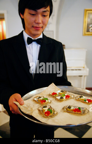 Août 2008 - Waiter holding a plate of caviar rouge à l'Empire russe, restaurant, St Petersbourg, Russie Banque D'Images