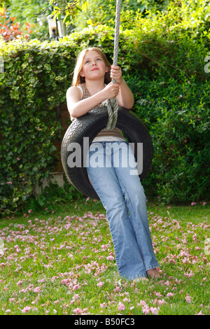 12 ans, fille, jouant sur balançoire pneu Banque D'Images