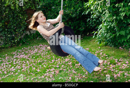 Jeune fille âgée de 12 swinging sur balançoire pneu Banque D'Images