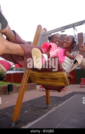 Smiling afro-caraïbes enfants on swing Banque D'Images
