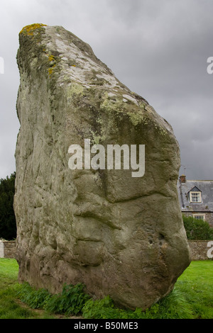 Avebury cercle de pierre néolithique, un henge. Le quartier Nord-Ouest, une grande pierre dans la crique, sous les nuages gris de pluie de tempête, atmosphérique. Banque D'Images