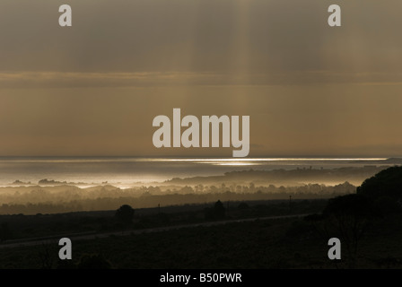 Rayons de soleil céleste brisant les nuages et lumière sur l'eau. Faisceaux de lumière chatoyante et réfléchissant sur l'océan. Banque D'Images