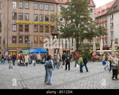 Les piétons les personnes à station météorologique sur place avec Lorenz Nassauer Haus Chambre Nassau en arrière-plan en Nuremberg Banque D'Images