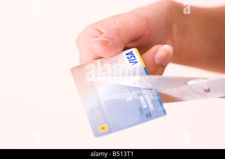 Coupe les mains avec des ciseaux de carte de crédit Banque D'Images