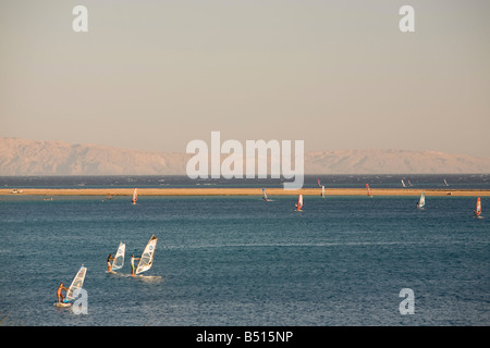 Les véliplanchistes en Mer Rouge resort de Dahab en Egypte avec l'Arabie saoudite dans l'arrière-plan Banque D'Images