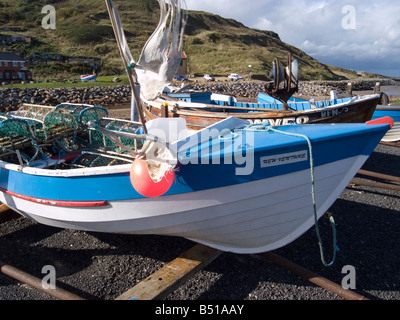 Petit bateau de pêche ou un nouveau projet appelé coble fraîchement peint et rempli de nouveau les casiers à Skinningrove Cleveland UK Banque D'Images