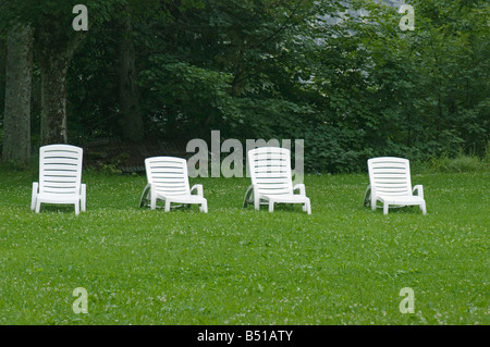 Chaises longues blanc vacants sur la pelouse Banque D'Images