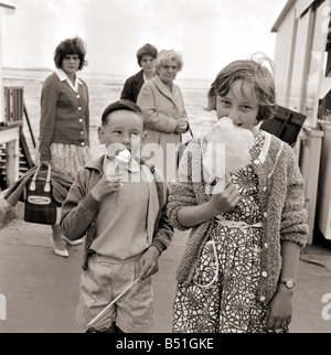 Centres de vacances à Southend dans l'Essex, deux jeunes enfants de manger une glace et la barbe à papa les vacanciers en plein air Journée jours hors vacances en Bretagne Juin 1962 Banque D'Images