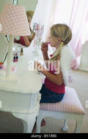 Little Girl Putting On Lipstick Banque D'Images