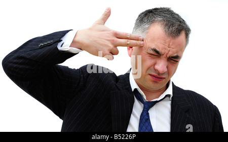 Un homme d'affaires points ses doigts à sa tête, faisant signe qu'il va se tuer. Photo par Patrick Steel Patricksteel Banque D'Images