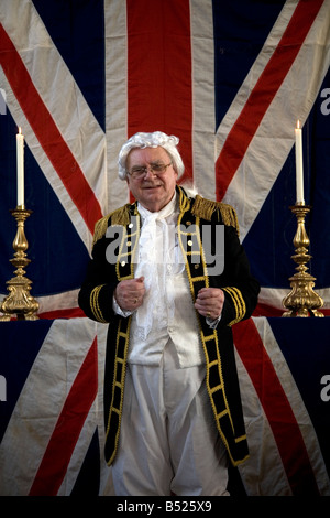 Un homme habillé en costume d'un officier de la Royal Navy se tient devant un drapeau de l'Union européenne sur l'anniversaire de Trafalgar. Banque D'Images