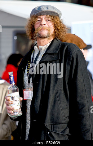 Sans-abri heureux homme tenant une bouteille de vodka Banque D'Images