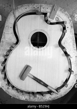 Les Guitares Lowden à Bangor en Irlande du Nord Co Nov 99 chevilles en bois tenir la consolidations fraîchement collées en place George Lowden a montré les premiers signes d'un génie alors qu'il n'avait que 10 en 1961 avec l'aide d'un maître vers le bas il a fait sa première guitare hors de panneaux durs avec des clous pour frets et ligne de pêche pour les chaînes et maintenant il est président d'une compagnie de guitares Lowden qui fête un quart de siècle dans les affaires faisant l'une des meilleures guitares dans le monde Banque D'Images