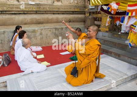 Des moines bouddhistes prient en vertu de l'arbre de Bodhi à Bodhgaya, Etat du Bihar, Inde. Banque D'Images