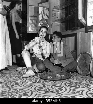 Actrices françaises voir l'artisanat local qu'elles sont prises d'une visite guidée de la ville de Marrakech au Maroc par un guide local. Décembre 1952 ;C5919-004 Banque D'Images