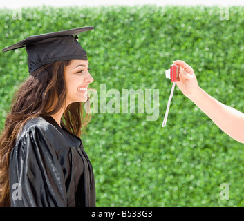 Middle Eastern woman in cap and gown avoir photographie prise Banque D'Images
