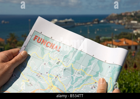 Gros plan de l'homme regardant la carte avec le port de Funchal en arrière-plan Madère Portugal Europe de l'UE Banque D'Images